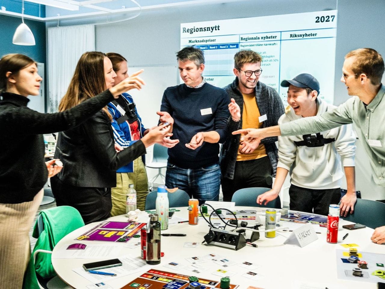 I bakgrunden står en vit get och i förgrunden häller någon upp mjölk i en behållare. 