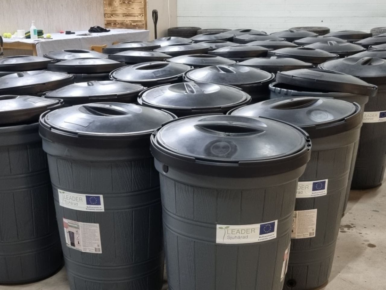 Ett rum fyllt av gråa vattentunnor.