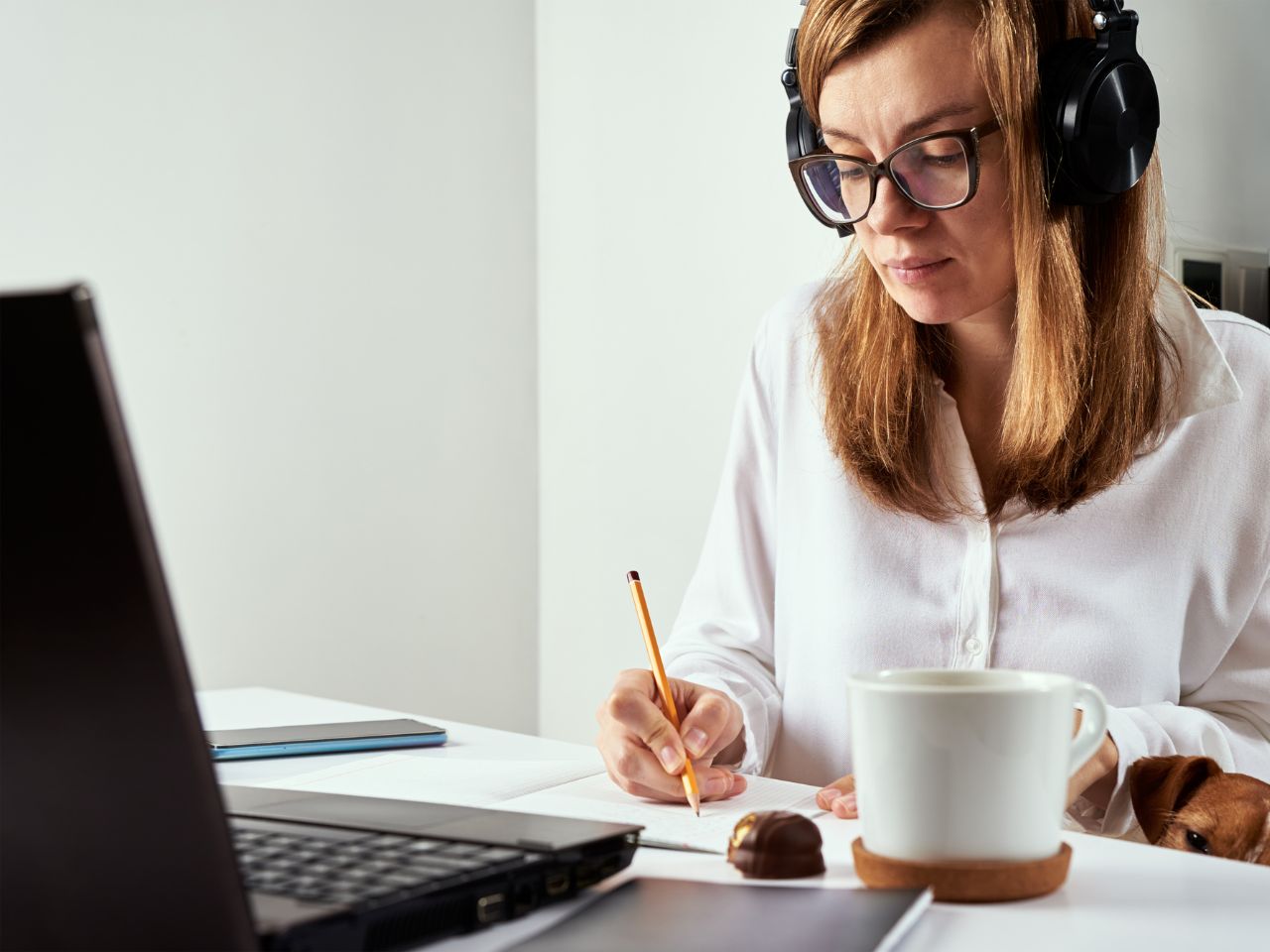 Kvinna vid dator, skärm full av foton på bakverk.