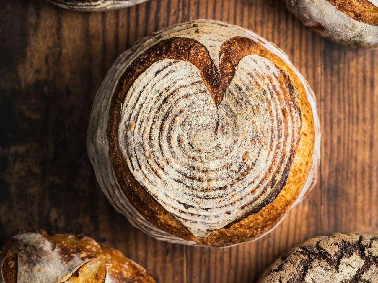 I bakgrunden står en vit get och i förgrunden häller någon upp mjölk i en behållare. 