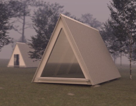 En trekantig stuga med brant tak och glasvägg på en gräsmatta och med träd bakom.